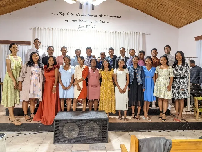 Les choristes en robes et chemises de couleurs variées, devant l’estrade de l’église